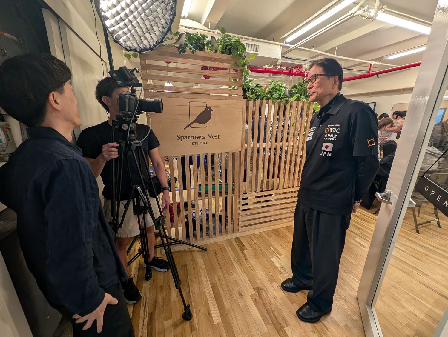 A broadcast interview in front of the Sparrow's Nest Studio sign during the M.League U.S. Tour